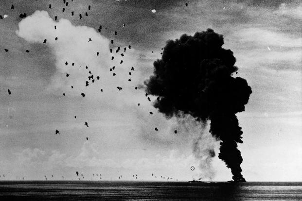 USS Abner Read (DD 526) afire and sinking in Leyte Gulf, November 1, 1944, after being hit by a kamikaze. A second Japanese suicide plane (circled) is attempting to crash another ship; however, this one was shot down short of its target. (U.S. Navy photo)