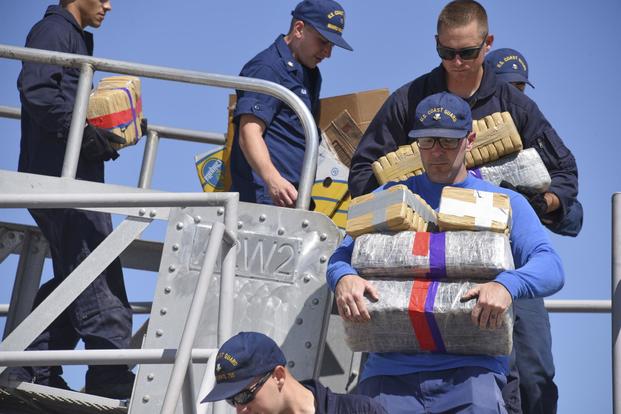 The crew of the Coast Guard Cutter Douglas Munro offload bales of drugs during a drug offload in Coronado, California, July 11, 2019. (U.S. Coast Guard/Petty Officer 1st Class Mark Barney)