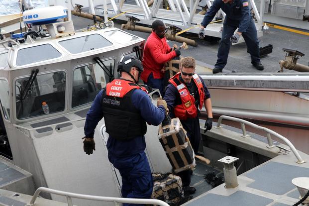 U.S. Coast Guard Cutter Munro (WMSL 755) crew members transfer bales of cocaine from the ship’s 35-foot Long Range Interceptor small boat to the cutter June 6, 2019. (U.S. Coast Guard photo)