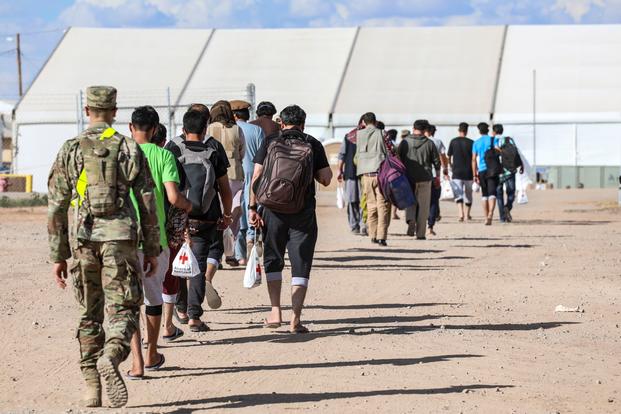 Afghan evacuees walk to their living quarters at Fort Bliss, Texas. 