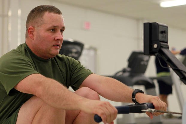 A Marine works out on a rowing machine.