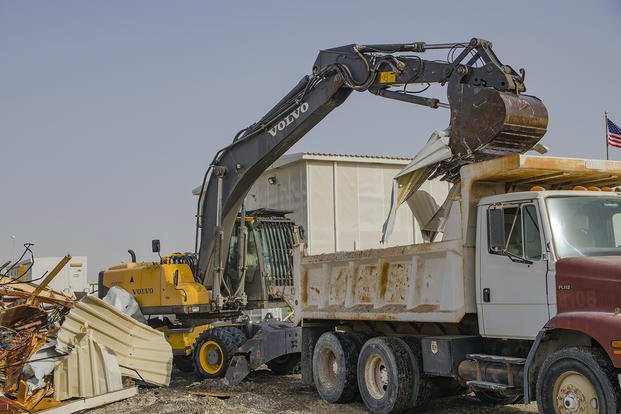 Staff Sgt. Nicholas Warkocz, pavements and heavy equipment operator, uses an excavator to remove debris from a demolished building at Al Dhafra Air Base, United Arab Emirates.
