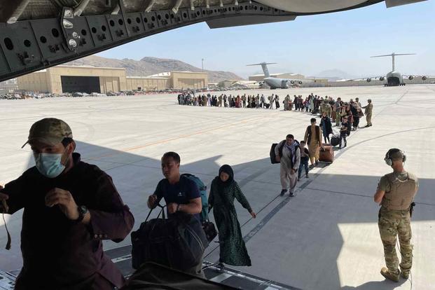 Afghan and American evacuees board a C-17 at Kabul International Airport 