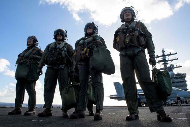Pilots stand on the flight deck of the USS Ronald Reagan.