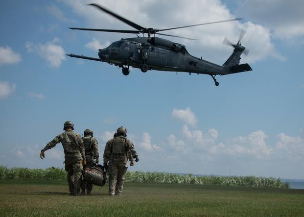 Green Berets with 1st Battalion, 1st Special Forces Group (Airborne), walk a simulated casualty on a Skedco litter to a U.S. Air Force HH-60 Pave Hawk helicopter during medical evacuation training Aug. 19, 2020, at Torii Station, Okinawa Prefecture, Japan.