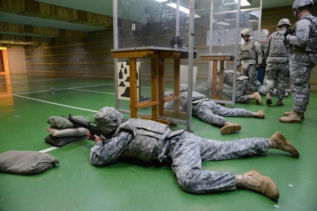 Four Soldiers of U.S. Army Garrison Benelux, settle at the prone supported position under the supervision of Sgt. 1st Class Jeremy King (NCO in charge) during the M16-A2 rifle weapon qualification at the Training Support Center 25 meter indoor range, in Chievres, Belgium, May 15, 2014.