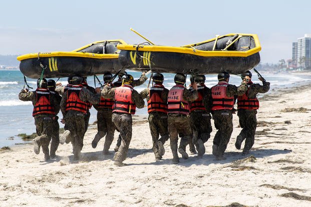 U.S. Navy SEAL candidates run with inflatable boats on their heads during the 'Hell Week' crucible of Basic Underwater Demolition/SEAL (BUD/S) training on Naval Amphibious Base Coronado, California.
