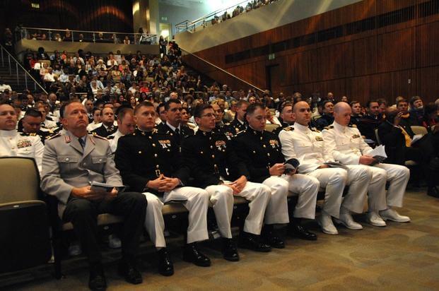 Military students prepare to receive diplomas during Naval Postgraduate School's spring graduation.