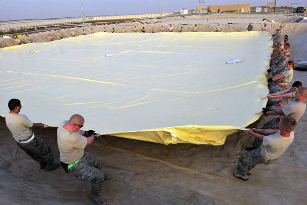 Airmen of the 380th Air Expeditionary Logistics Readiness Squadron arrange a 200,000-gallon fuel bladder at an undisclosed location in Southwest Asia, April 4, 2013. (US Air Force photo/Christina Styer)