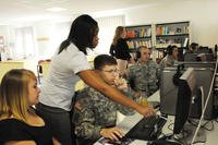 Theresita Cliett, Army Career and Alumni Program career counselor, talks a soldier and his wife through the USAJobs.gov job website. (Chelsea Bissell/U.S. Army)