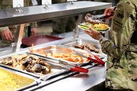 A culinary specialist adds a steak to a soldier’s plate at Fort Bliss, Texas.