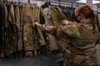 Senior Airman looks through maternity uniform options  at Langley Air Force Base.