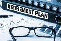 a binder marked retirement plan arranged with some data charts and reading glasses