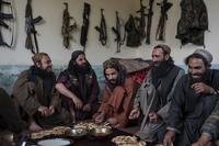 Taliban fighters enjoy lunch inside an adobe house that is used as a makeshift checkpoint