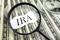 The word IRA appears under a magnifying, atop a fanned-out stack of cash.