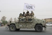 Taliban fighters patrol on the road during a celebration