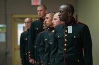 Marine recruits stand in line to have their uniforms fitted.