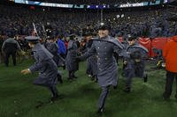 Army Cadets storm the field after defeating Navy in a college football game at Gillette Stadium.
