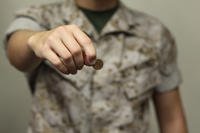 Servicemember holding a penny.
