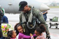 An Airman hugs his children
